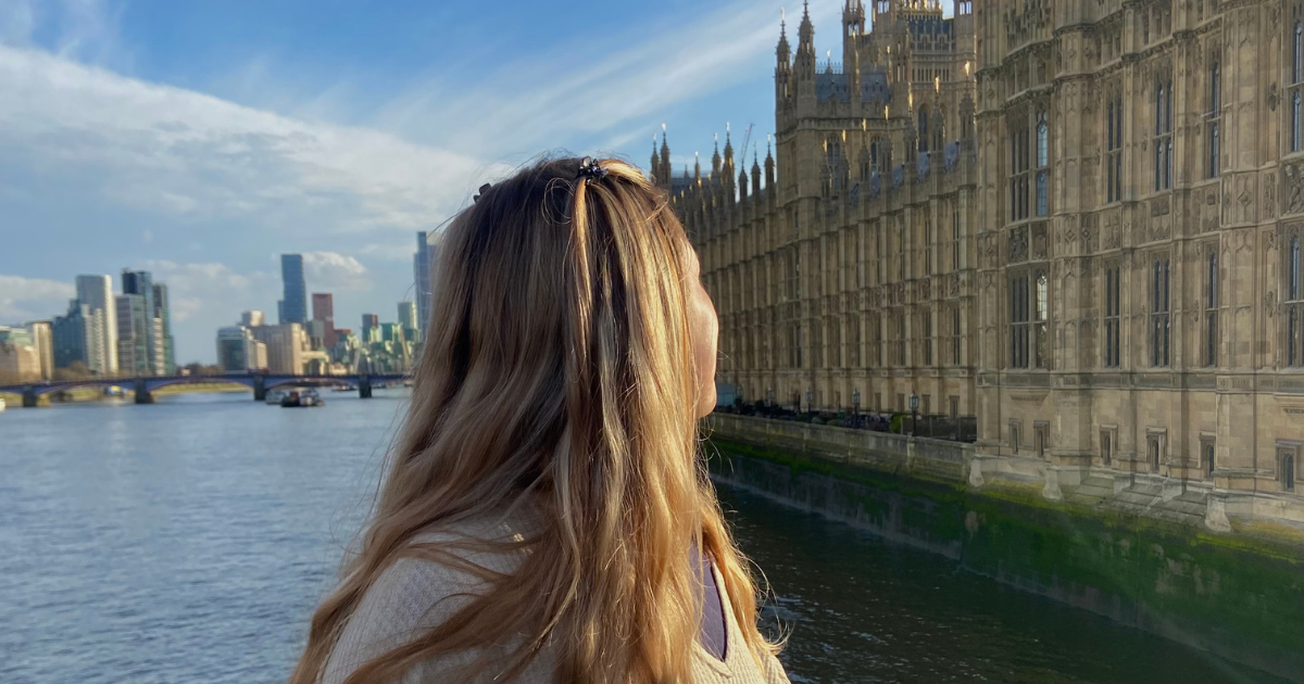 Young woman looking over her shoulder at the PAlace of Westminster
